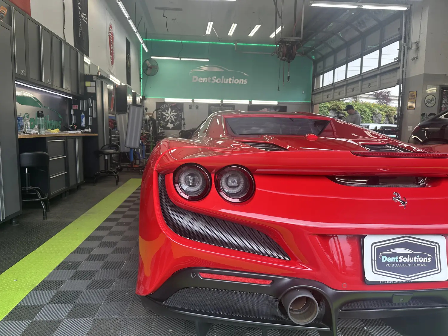 A red sports car parked in the Dent Solutions NW service bay in Bellevue