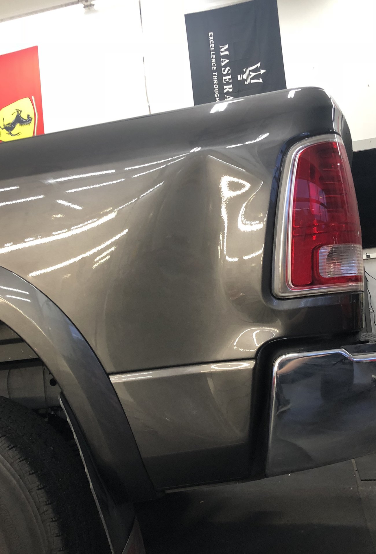 The dented bedside of a gray Dodge Ram before paintless dent repair in Bellevue