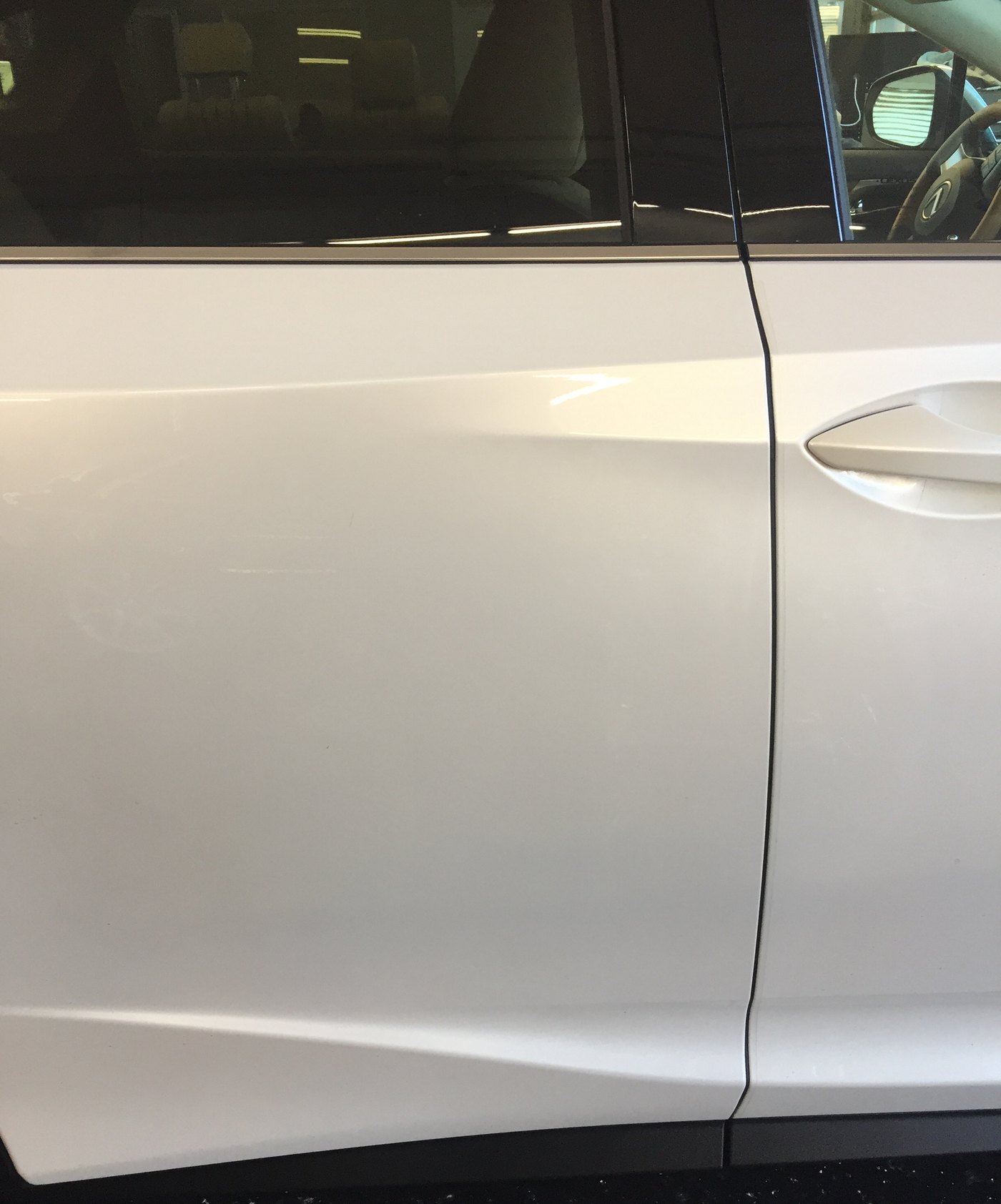 The same Lexus door after paintless dent repair, the reflection running straight and the factory paint untouched