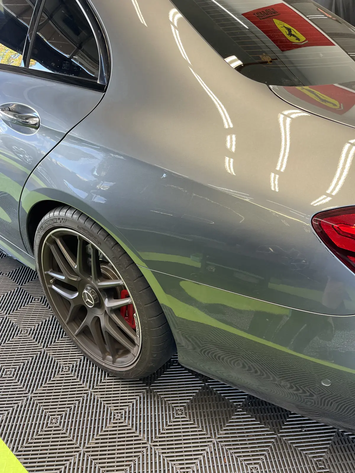 The rear quarter of a gray Mercedes-AMG sedan after paintless repair