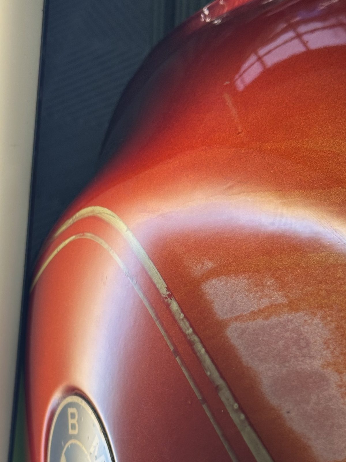 The same motorcycle tank after paintless dent repair with the original paint untouched