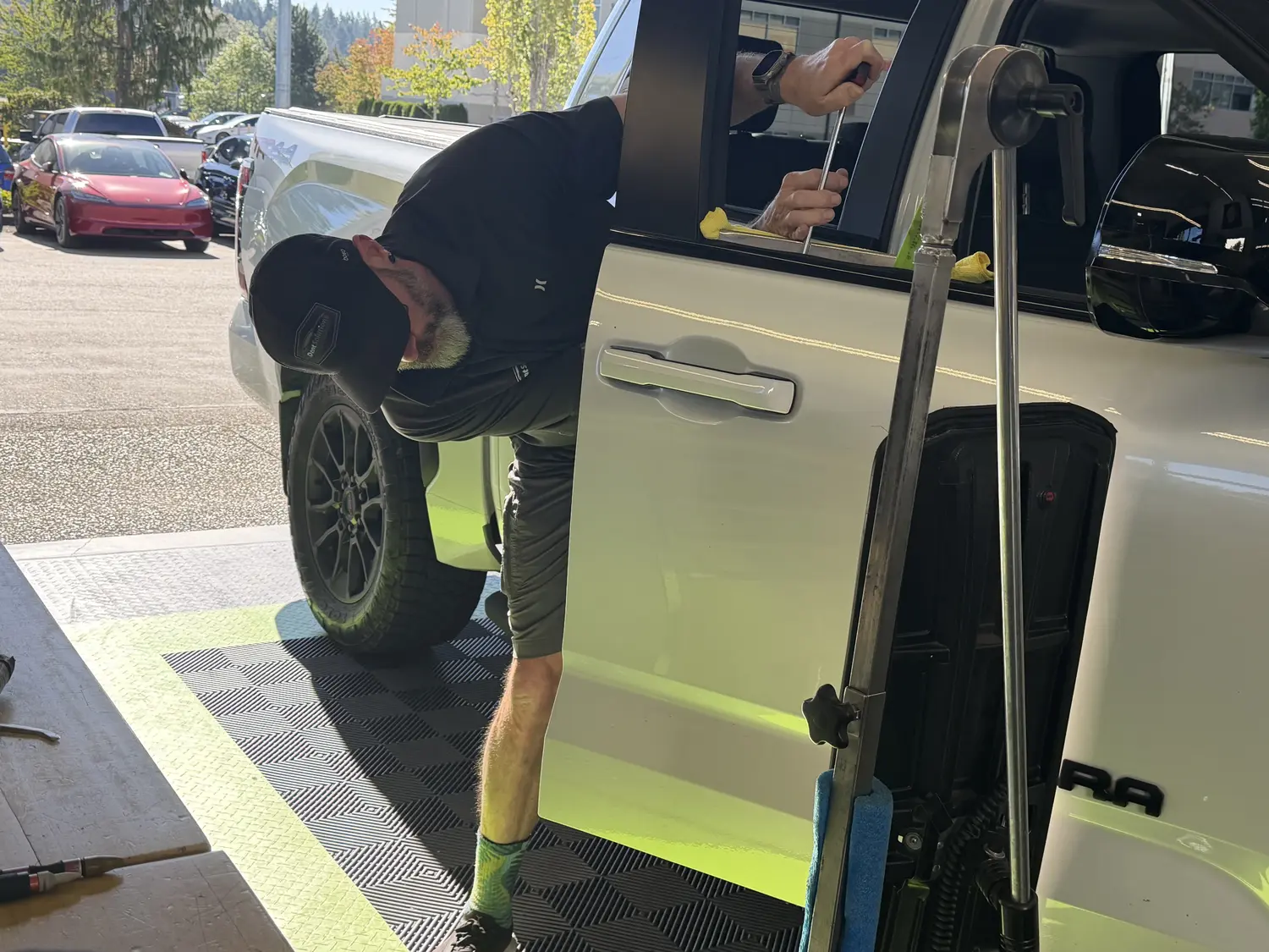 Our technician working a rod inside the door of a white Toyota Tundra