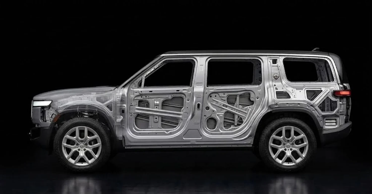 The same Rivian R1S with the panels made transparent, showing the aluminum door, the steel fender and the bracing that fills the one-piece rear quarter