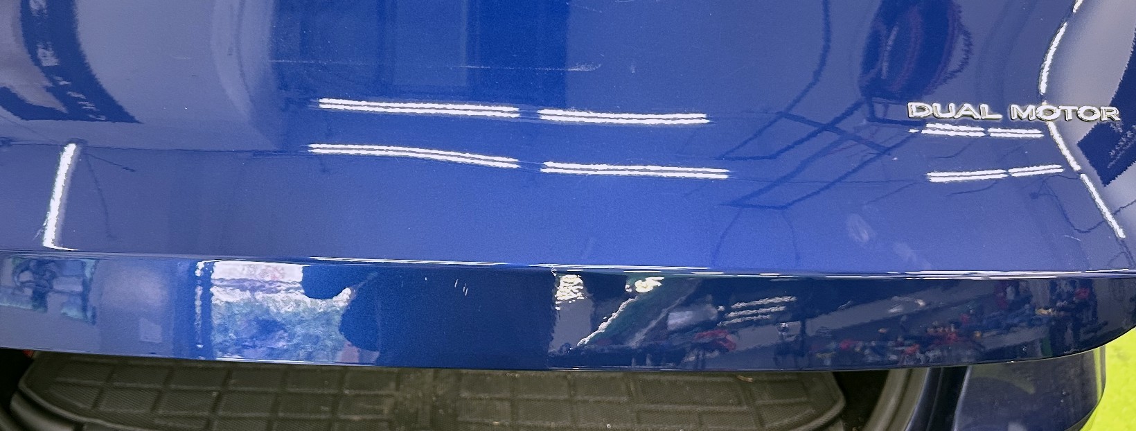 The same tailgate after paintless repair, the body line straight again and the factory paint untouched